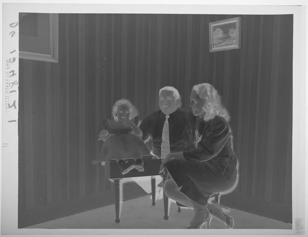 Untitled (little girl sitting on top of miniature piano, parents to her side) by Paul Gittings