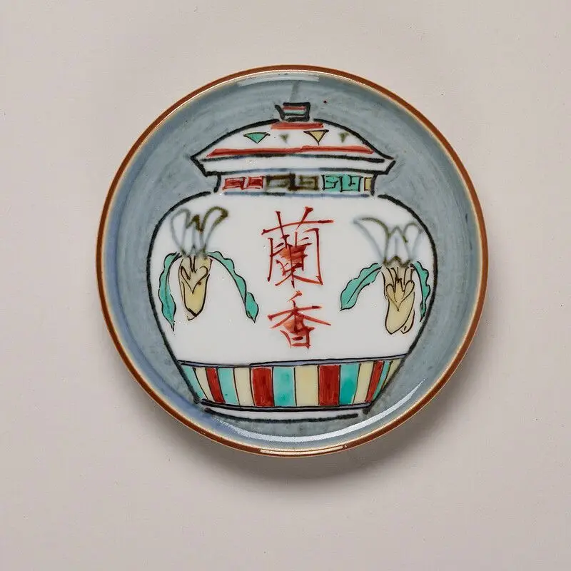 Ceramic plate decorated with an orchid pot by Tomimoto Kenkichi