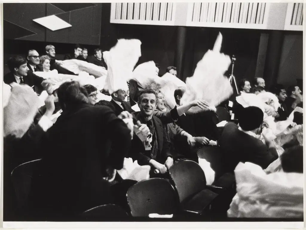 Audience members participating in Paper Piece (1960), performed during Fluxus Festival/Theatre Compositions/Street Compositions/Exhibits/Electronic Music, Hypokriterion Theater, Amsterdam, June 23, 1963 by Benjamin Patterson