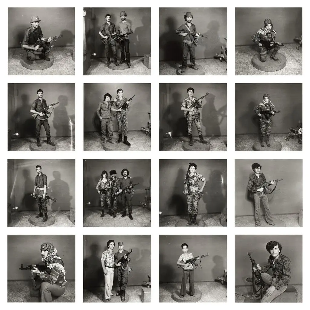 After They Got the Right to Arms. Fourteen young men posing with guns. by Akram Zaatari