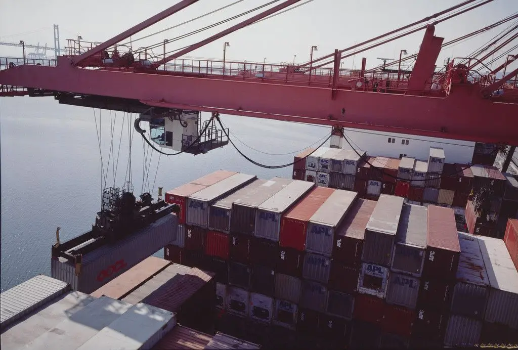 Hammerhead crane unloading forty-foot containers from Asian ports. American President Lines terminal. Los Angeles harbor. San Pedro, California from the series Fish Story by Allan Sekula