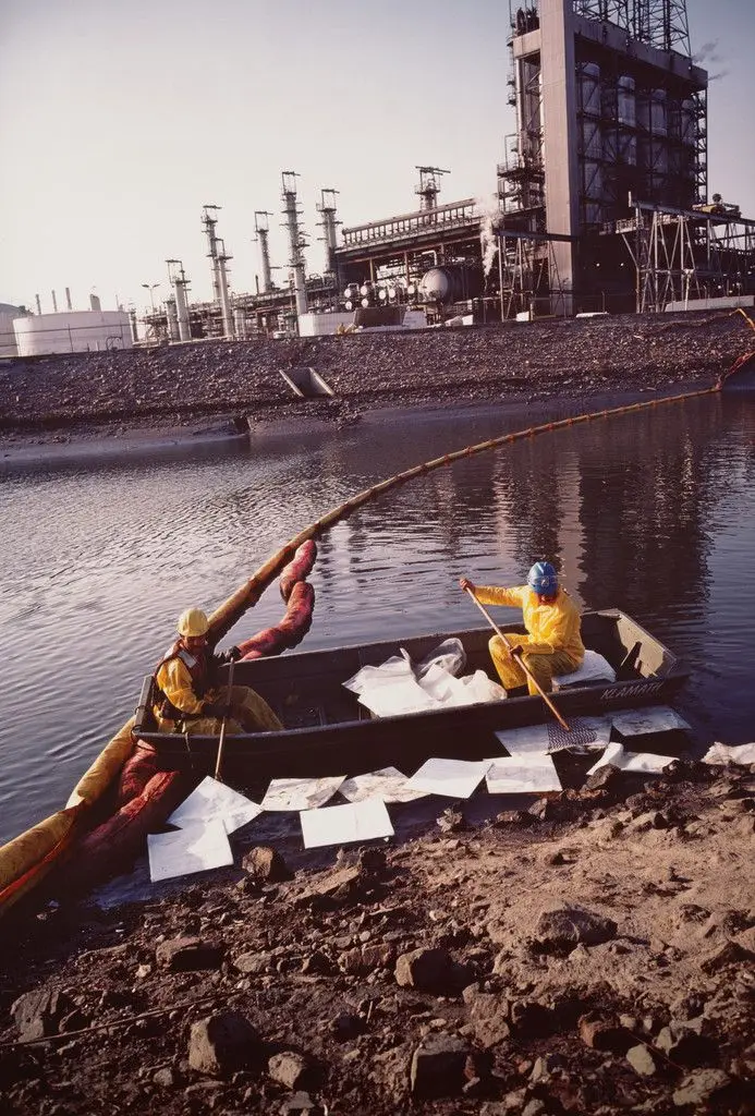 Workers cleaning up chemical spill after refinery explosion. Los Angeles harbor. Wilmington, California from the series Fish Story by Allan Sekula