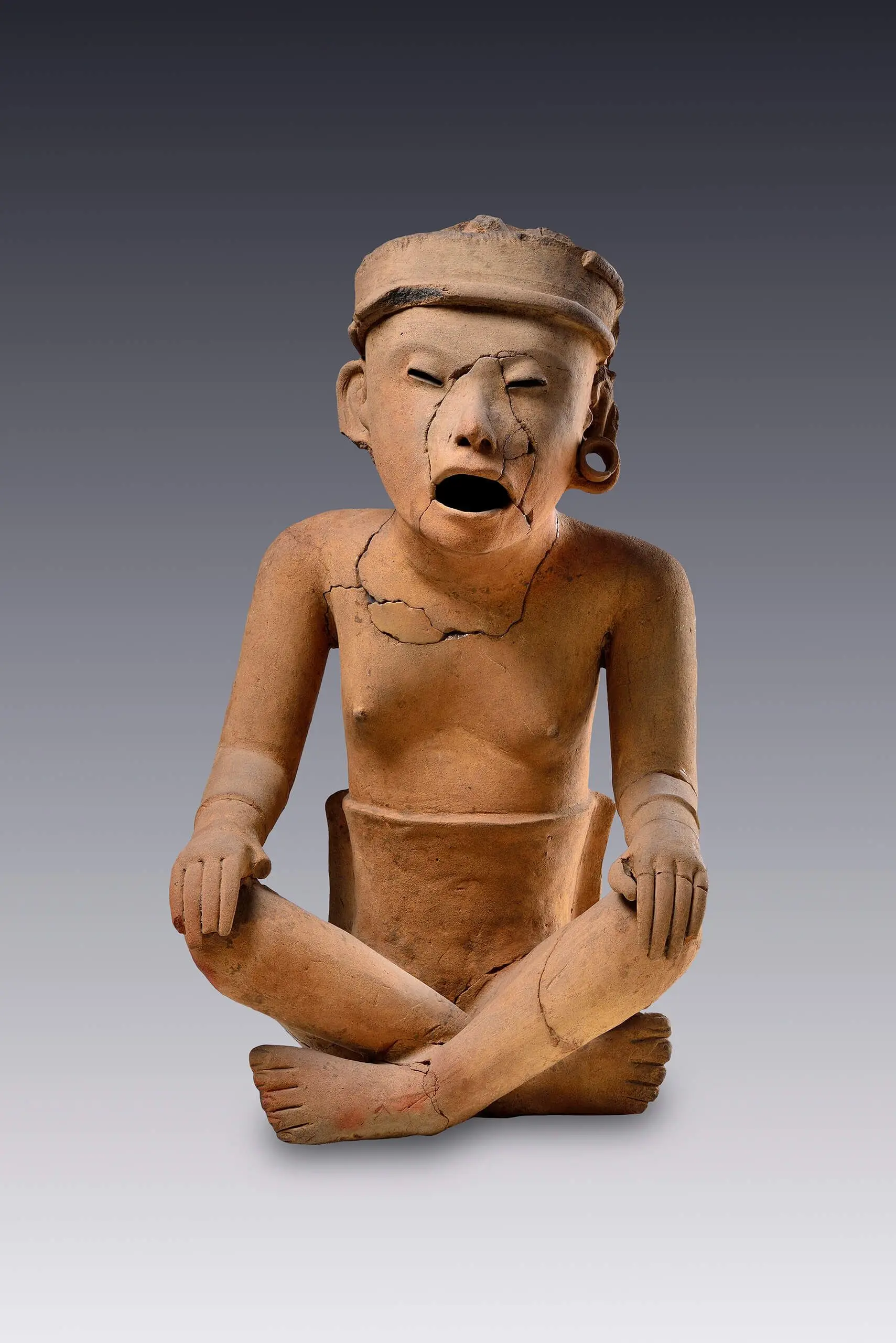 Escultura de hombre sentado que parece entonar un canto by Centro de Veracruz