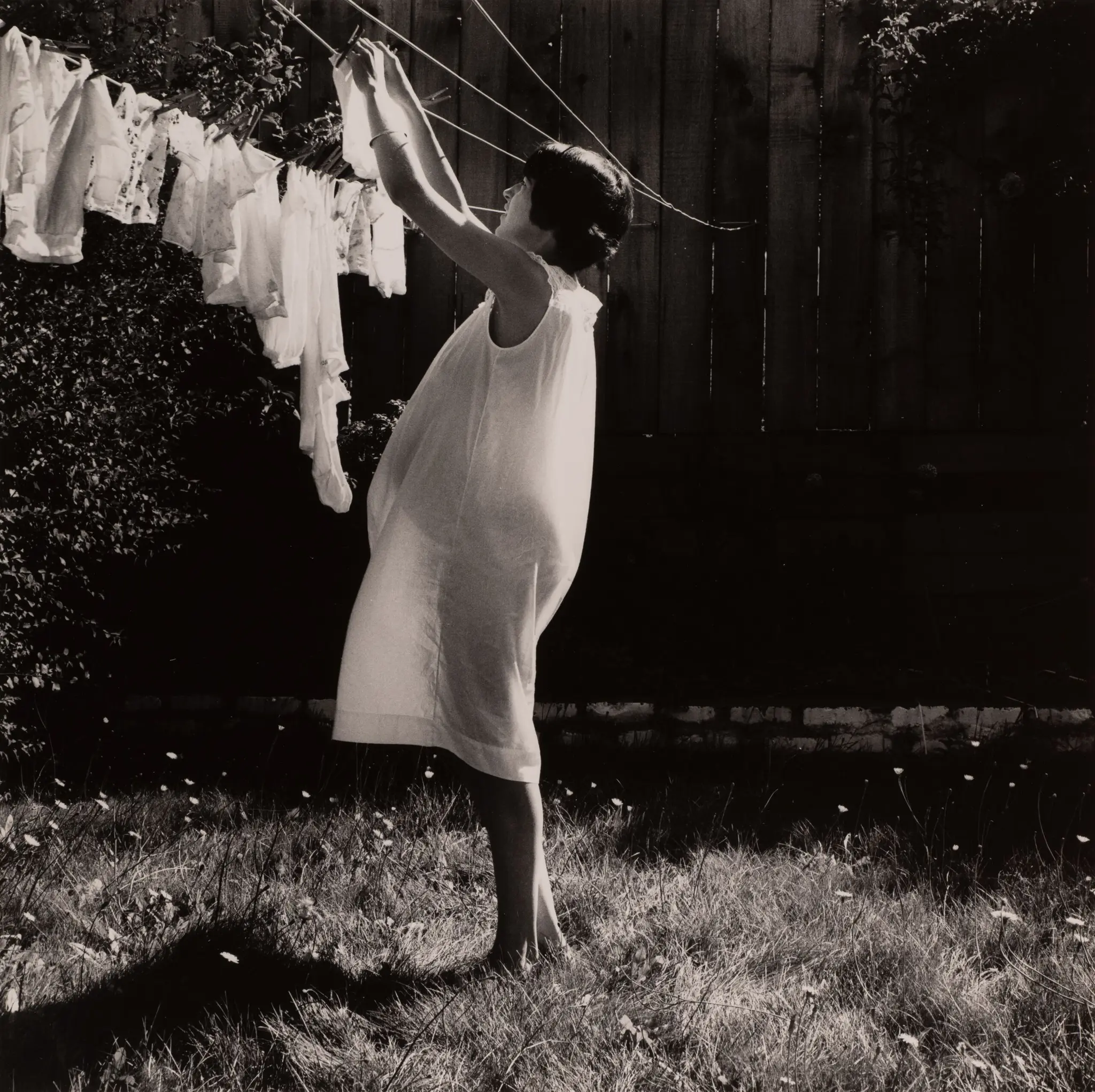 Sonia (pregnant woman hanging laundry) by Joanne Leonard