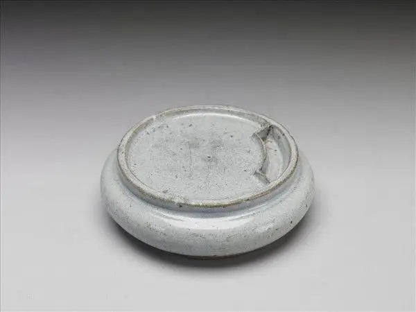 Round porcelain inkstone in moon-white glaze (with a jade-inlaid case) by Unknown artist