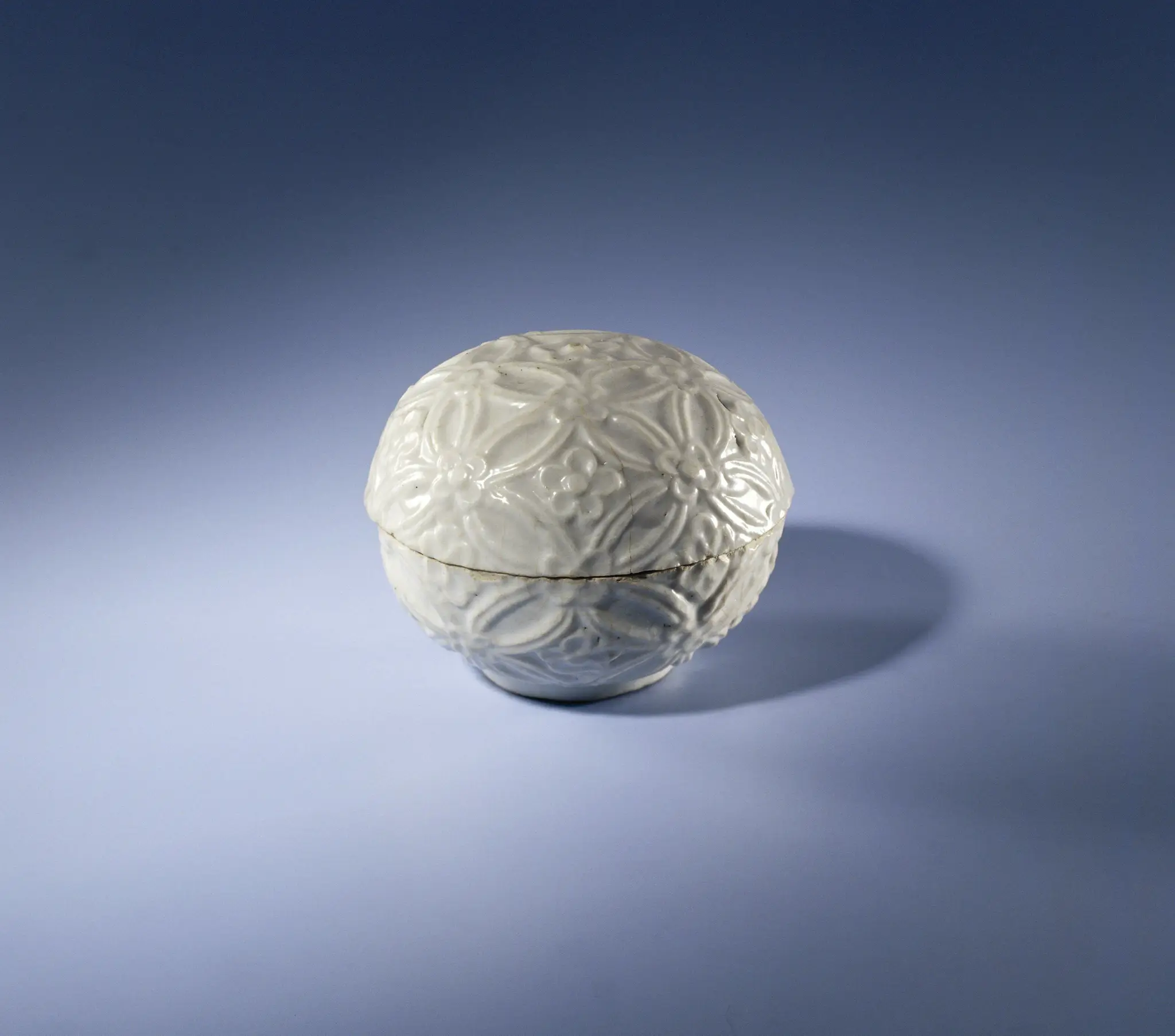 Round-bodied box with continuous flower motif in relief by anonymous