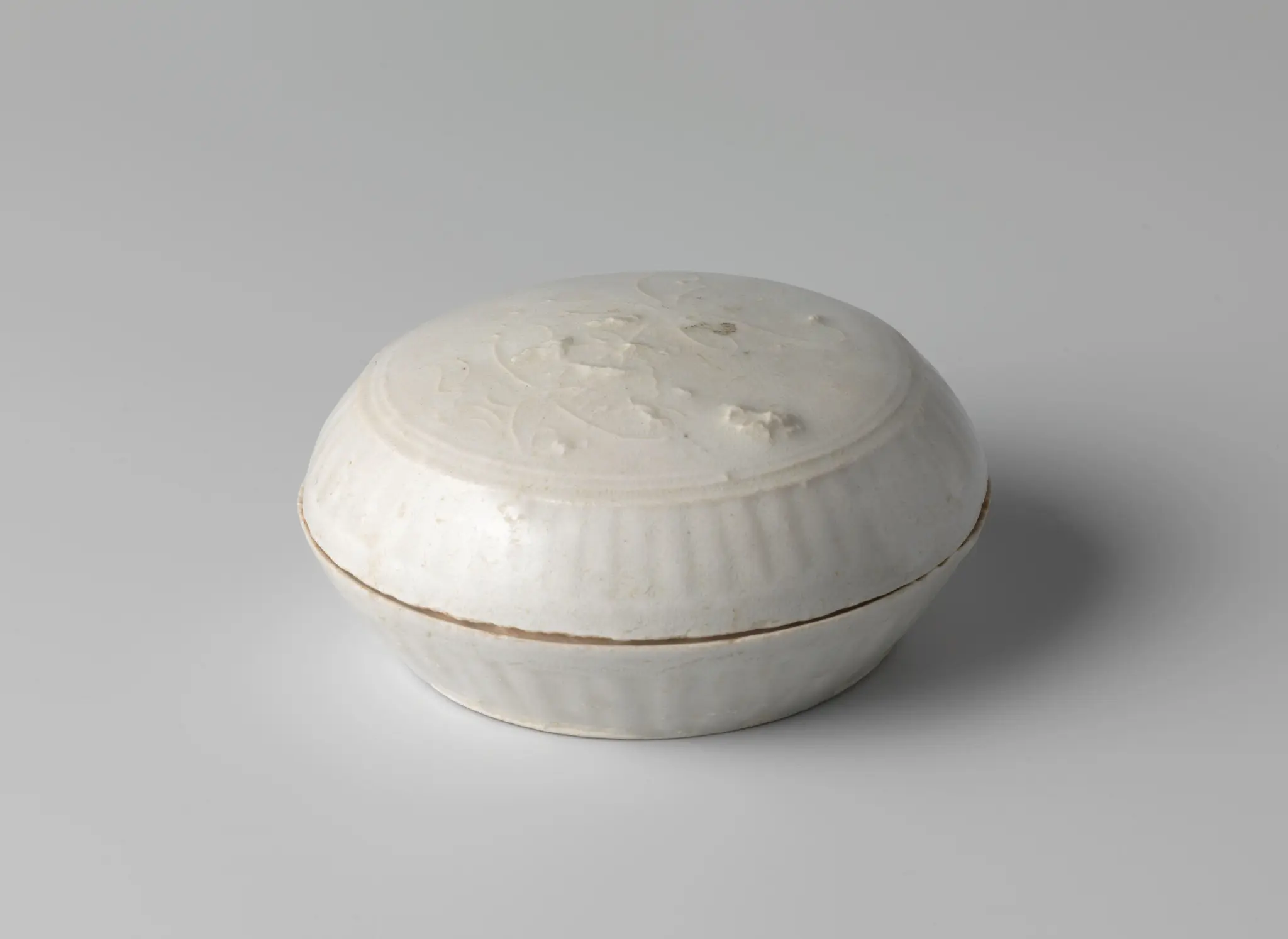 Round box with a flower spray in relief and fluted sides by anonymous
