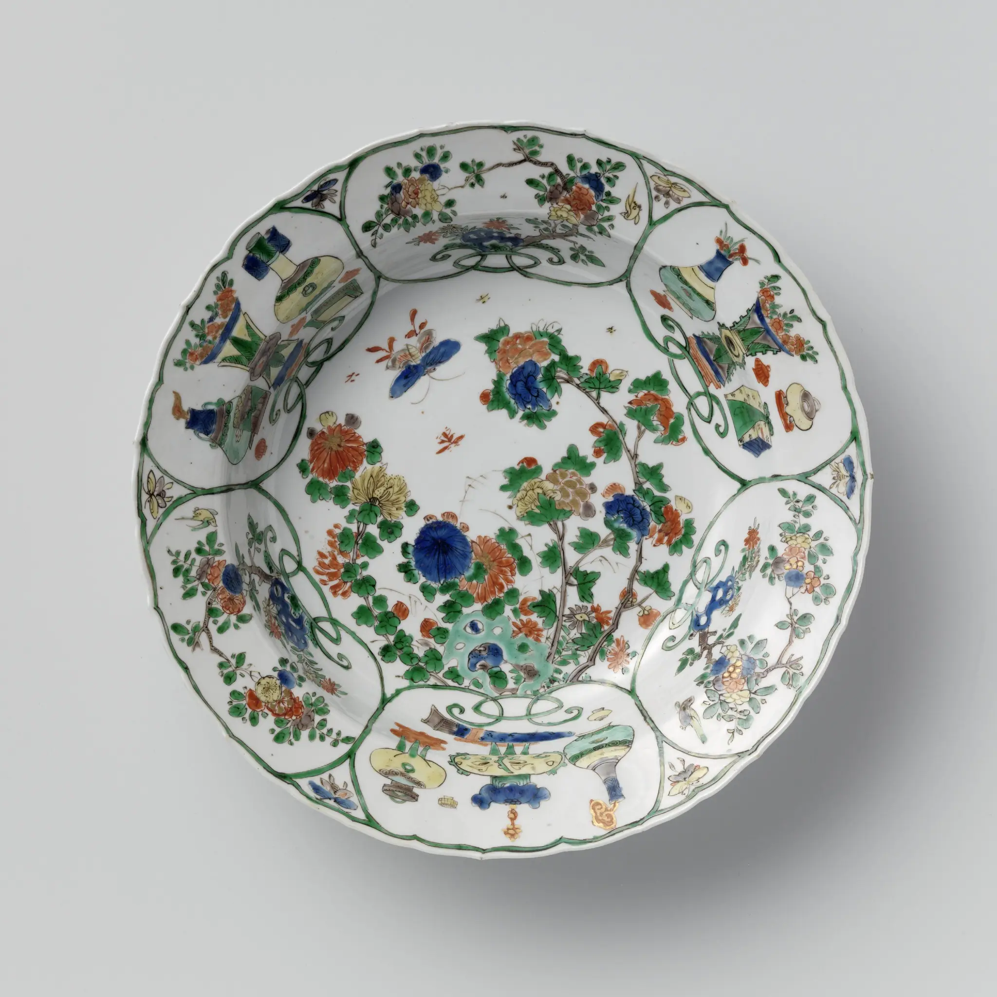 Deep dish with flowering plants near a rock and antiquities by anonymous