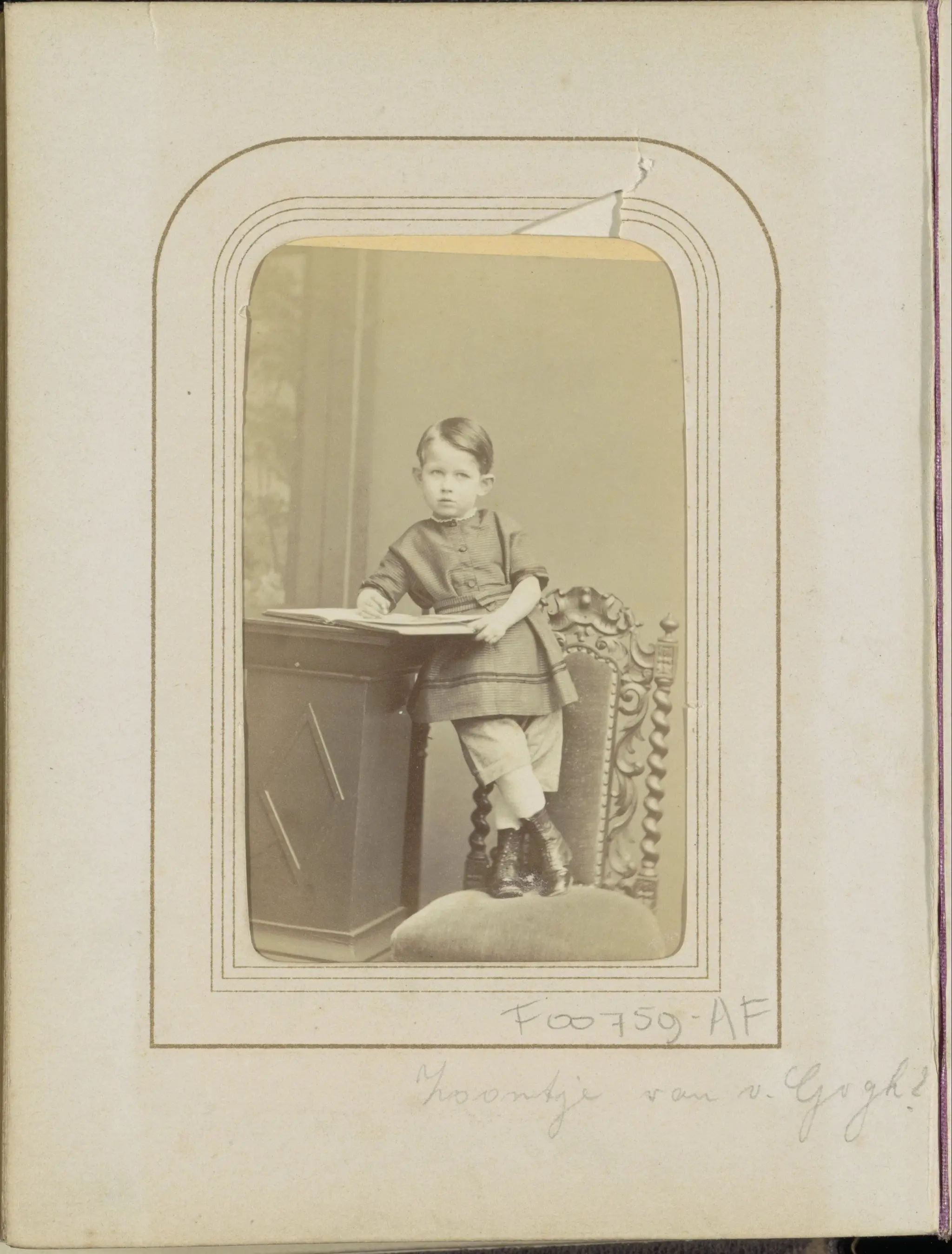 Portret van een jongen met een boek op een stoel, aangeduid als zoontje van Van Gogh by Albert Greiner