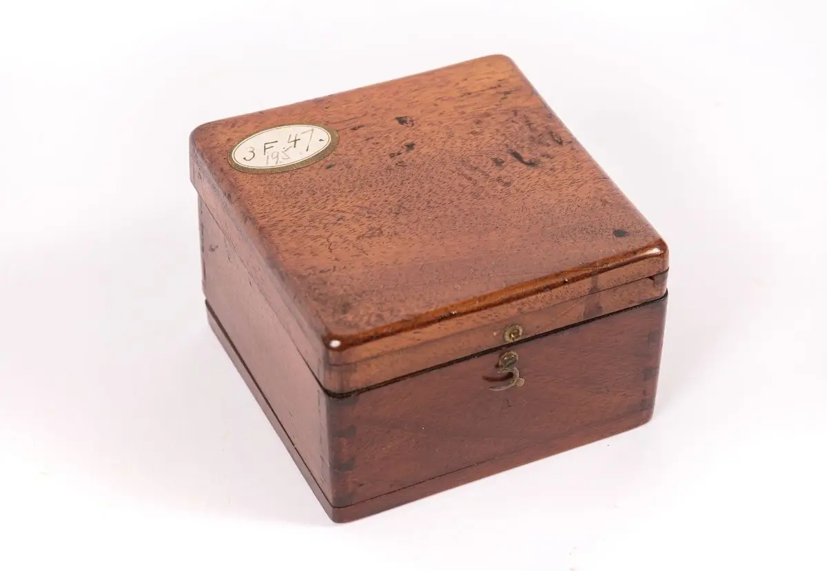 Kompass i mahognylåda, jämte kubiskt fundament av trä by Unknown artist