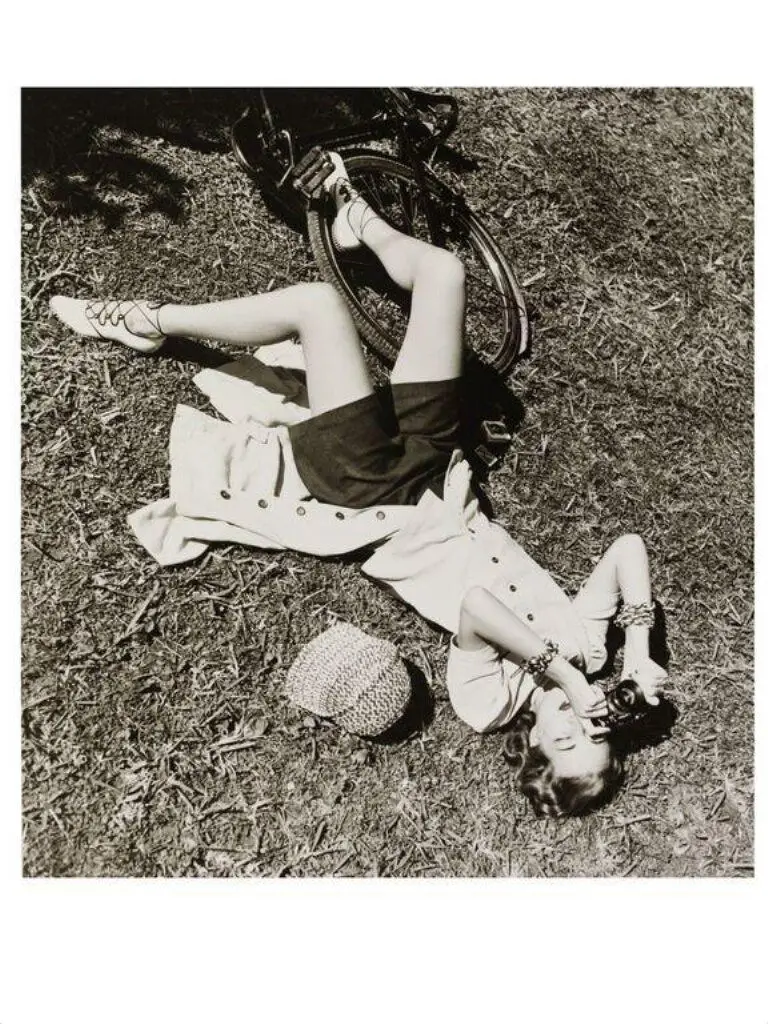 Girl with Camera Lying on Grass by dahl-wolfe, louise